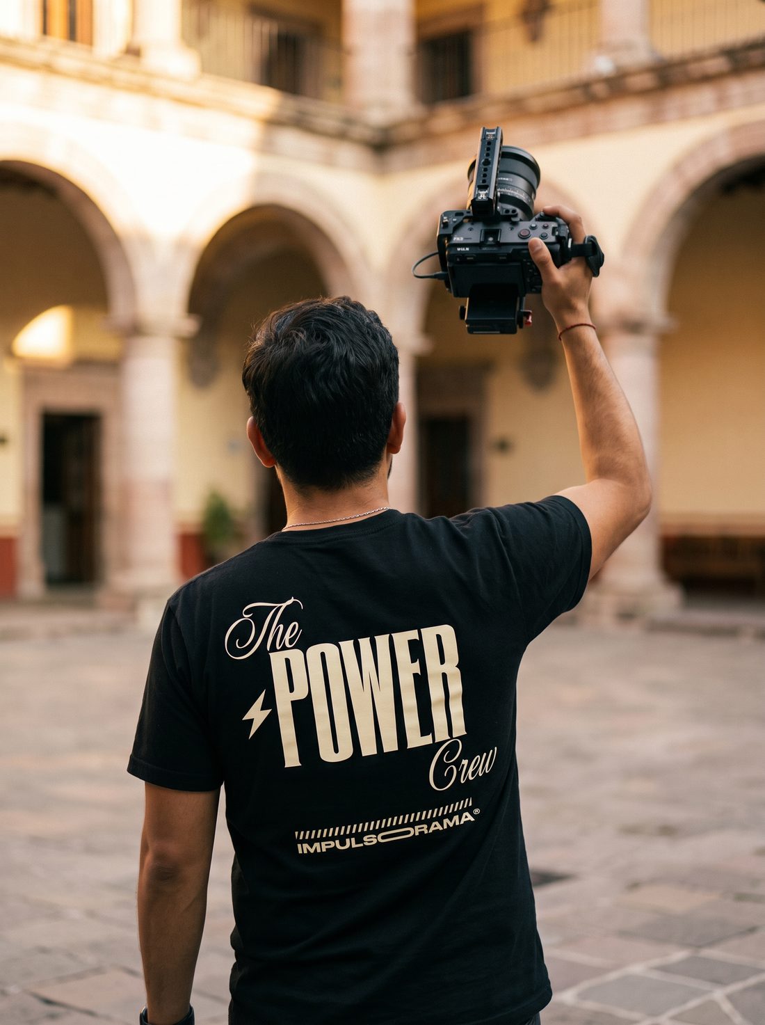 Camarógrafo del crew de Impulsorama de espaldas con la playera The Power Crew, sosteniendo una cámara Sony Cinema Line